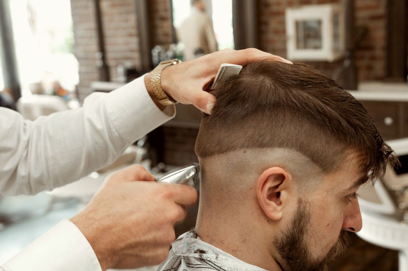 A barber trimming a fade
